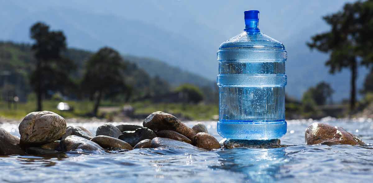water cooler bottle on rock in stream